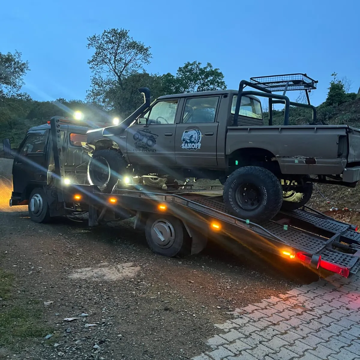 Salihli Oto Çekici — gece, amber ışıkları yanan kurtarıcıya yüklenen 4x4 pickup
